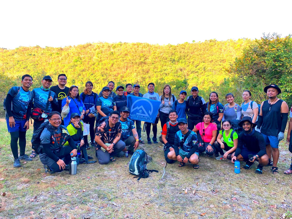 A joyful hiking team poses after conquering a trail.